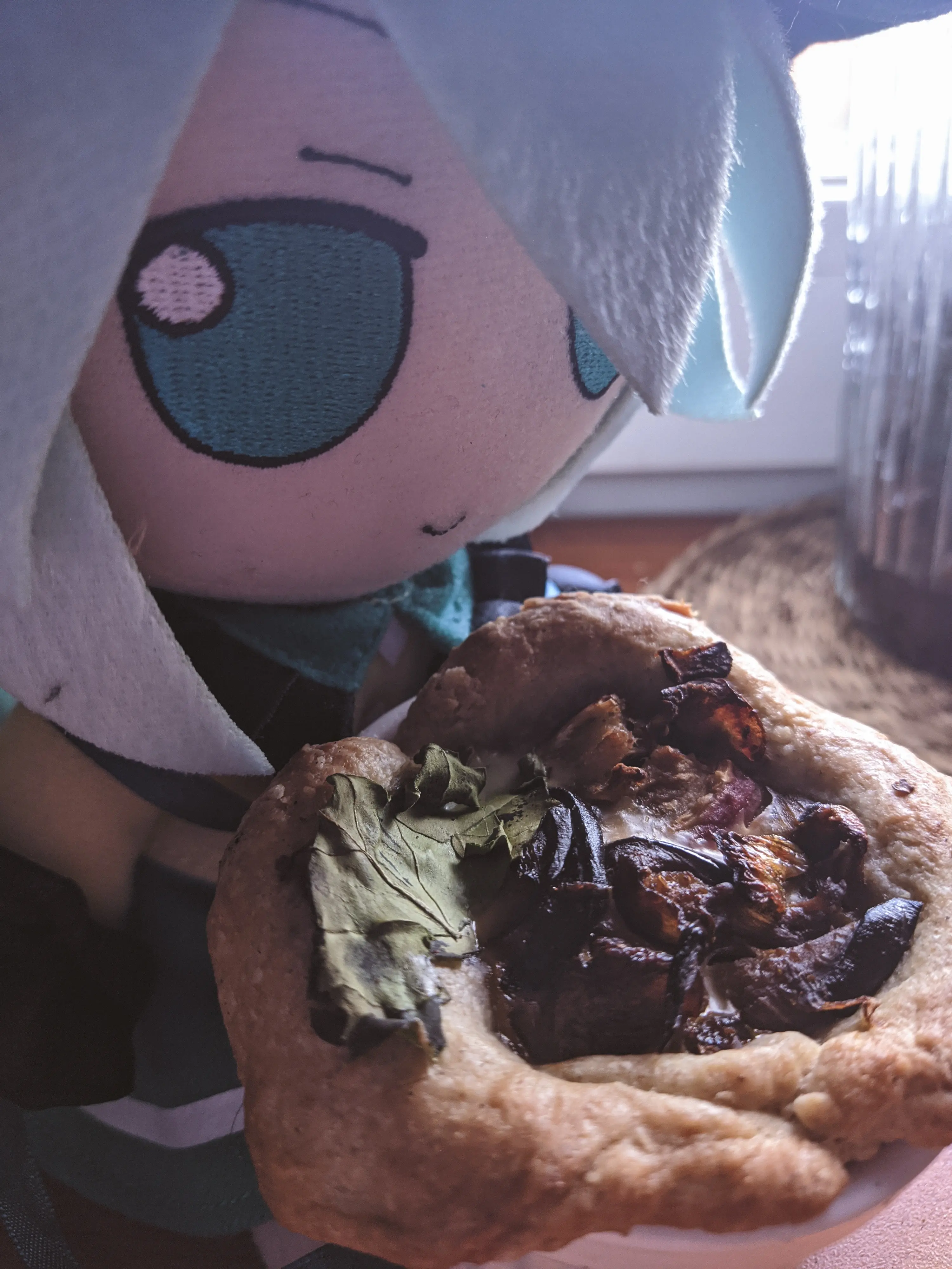 Photograph of a Koishi Fumo next to a small eggplant quiche